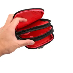 Dettaglio ravvicinato della borsa da cintura con scomparti multipli e fodera rossa vivida.