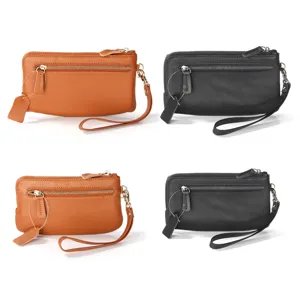 Gros plan des détails de la pochette portefeuille zippée en cuir véritable avec lanière de poignet.