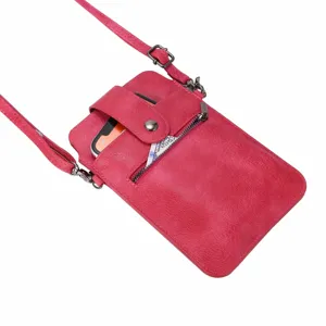 Detailopname van de roze lederen crossbody tas voor mobiele telefoons met ritsvak en riem.