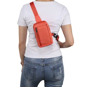 Detail view of the orange nylon sling bag showing zipper pocket and adjustable strap.