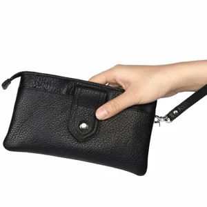 Détail de pochette poignet en cuir noir, matière cuir de vache souple, poche zippée sûre.