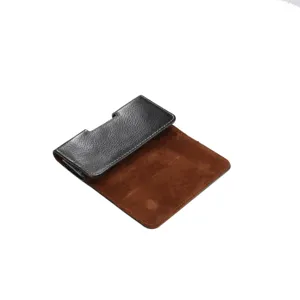 Detailaufnahme mit schwarzem Litschi-Muster-Leder und braunem Wildleder-Futter der Handytasche.