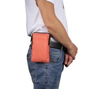 Detailansicht der orangen vertikalen Handytasche am Gürtel, kompaktes und praktisches Design.