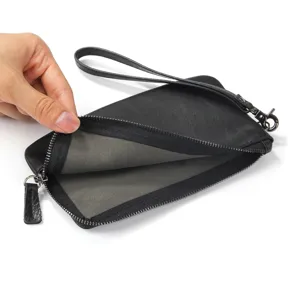 Vue de détail en gros plan du portefeuille zippé en cuir noir avec doublure intérieure lisse.