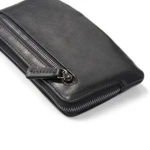 Vue détaillée de la pochette zippée en cuir véritable noir montrant texture et quincaillerie.