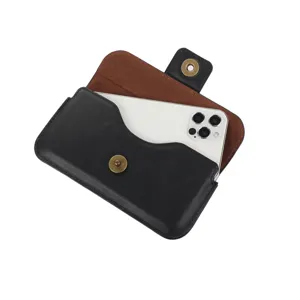 Détail de l'étui de téléphone en cuir noir avec intérieur marron et bouton-pression.