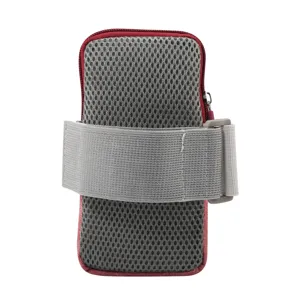 Detalle de primer plano de la bolsa de brazo deportiva de malla gris con borde rojo y correa.