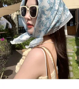 Close-up detail of the vintage blue floral lace triangle headscarf, elegant seaside style.