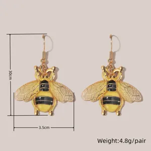 Nahaufnahme der goldenen Bienen-Ohrringe im Vintage-Stil, feine Handwerkskunst und Emaille.