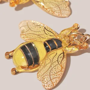 Nahaufnahme Detail vintage goldener Bienen Ohrringe mit feinen bernsteinfarbenen Flügeln.