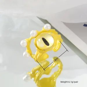 Cute yellow cat eye monster open ring with white pearls, detailed fashion jewelry shot.