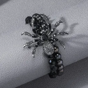 Primer plano detallado de la pulsera de araña gótica negra con diamantes de imitación y cuentas.