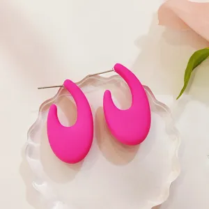 Detaillierte Nahaufnahme pinker geometrischer C-Ohrstecker, elegantes minimalistisches Design.