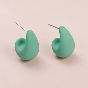 Close-up detail of mint green matte teardrop stud earrings, simple elegant minimalist style.