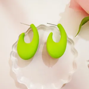 Süßigkeiten Farbe halbrunde C-förmige Ohrstecker Detail Nahaufnahme, minimalistischer Schmuck.