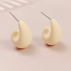 Close-up of minimalist cream teardrop stud earrings, cute macaron style daily jewelry detail.