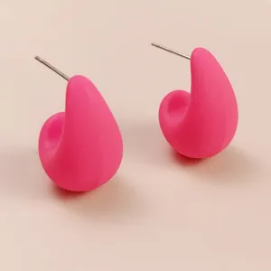 Close-up detail of trendy minimalist pink teardrop stud earrings with smooth metal pins.