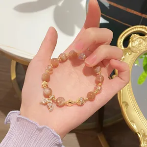 Close-up detail of the sweet orange moonstone and crystal bracelet with a mermaid tail.