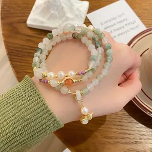 Multi-layer Tianshan green jade pearl bracelet with cute gourd pendant and gold elements.