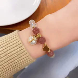 Close-up detail of the sweet strawberry quartz crystal bracelet featuring a cute ladybug pearl charm.