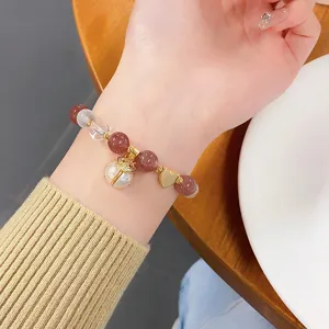 Detailed shot of sweet strawberry quartz and crystal beaded bracelet with cute pearl ladybug.