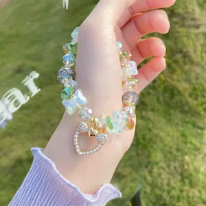 Detailed view of colorful crackle crystal beaded bracelet with cute butterfly and heart charm.