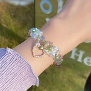 Close up detail of sweet crystal glass bead bracelet with sparkling heart bow charm for women.