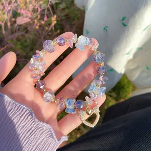 Close-up detail of crystal glass bead bracelet featuring cute butterfly charms and heart pendant.
