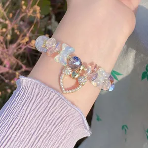 Delicate crystal glass bead bracelet featuring sweet butterfly and pearl heart pendant detail.