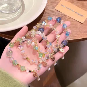 Vue détaillée de bracelets de perles en cristal doux avec charms cœur, design superposition.