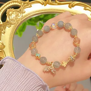 Exquisite mermaid tail pendant crystal beaded bracelet detail showcasing delicate gold accessories.