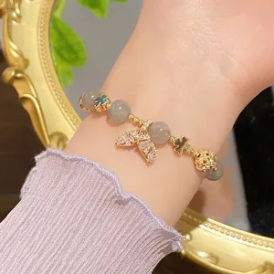 Exquisite mermaid tail bracelet detail shot featuring grey crystal beads and charming clover charms.