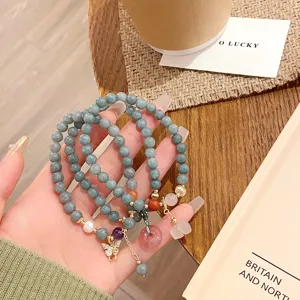 Détail du bracelet en perles de jade birman de 6mm avec pendentif papillon et boucle de paix.