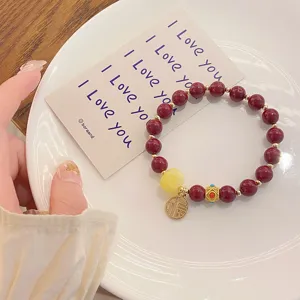 Bracelet de perles rouges de style chinois vintage avec pendentif chance et detail ambre