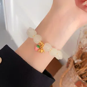 Squisito braccialetto di perle di loto con ciondoli di fragole e fiori, dettaglio elegante.
