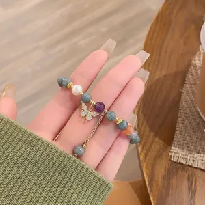 Gros plan détaillé du bracelet en pierre précieuse style ethnique avec pendentif papillon.