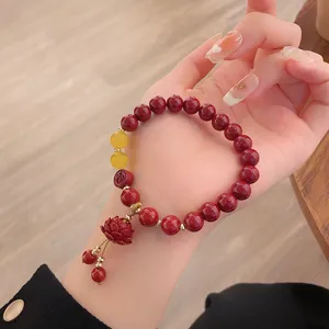 Bracelet rouge en cinabre de style chinois avec pendentif lotus et perle chance.