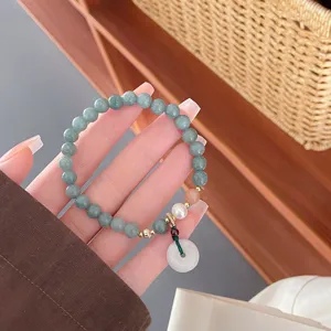 Gros plan détail de bracelet de perles de jade vert rétro chinois avec pendentif boucle.