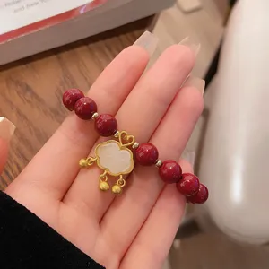 Bracelet perles cinabre rouge 8 mm avec pendentif verrou ruyi doré, style traditionnel chic.