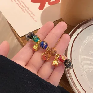 Bracciale in perline smaltate stile cinese con foglia d'oro e simpatici ciondoli.