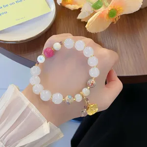 Gros plan d'un bracelet de perles en cristal de lotus style chinois doux avec de beaux pendentifs.