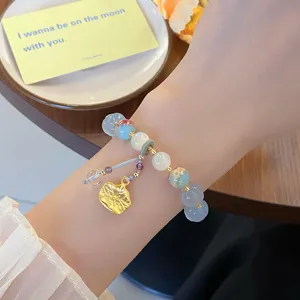 Gros plan sur le délicat pendentif lotus et le bracelet de perles colorées de style chinois.