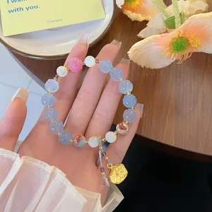 Vue de détail exquise d'un bracelet lotus de style chinois avec perles sculptées et breloques or.