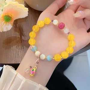 Vue détaillée d'un bracelet de perles de style chinois avec lotus et pierres colorées.