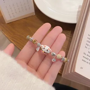 Handcrafted ceramic lucky cat bracelet with woven cord, beads and cute bell, aesthetic gift.