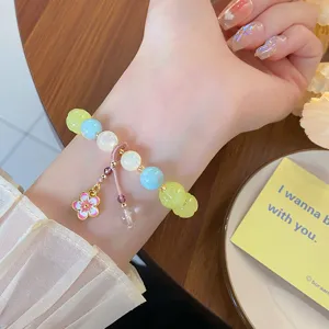 Gros plan détail du charmant bracelet de perles avec pendentif lotus et perles colorées.