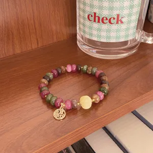 Colorful gemstone wheel bead bracelet detail view featuring a traditional Fu pendant design.