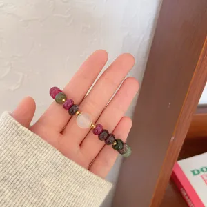 Close-up detail of vintage ethnic colorful gemstone wheel bead bracelet with golden spacers.