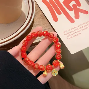 Bracciale di perle in vetro rosso cinese retrò con foglia d'oro e ciondoli di animali dorati.
