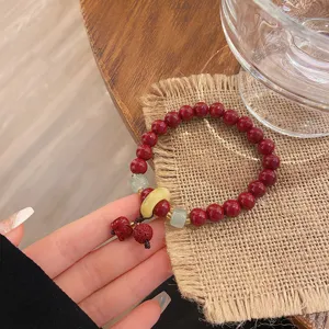Bracelet de perles de cinabre rouge style chinois avec éléphant et boucle de jade.